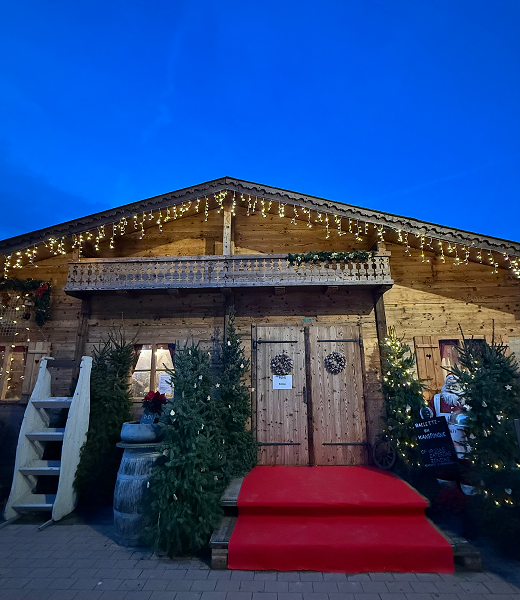 De Chalet: houten chalet met kerstverlichting en rode loper