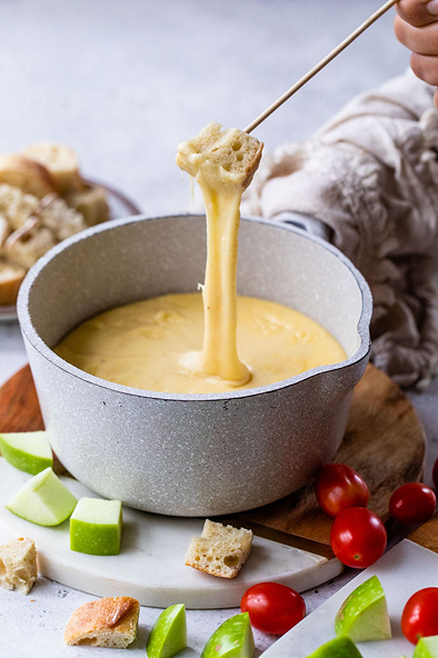 Kaasfondue met brood, appel en tomaatjes